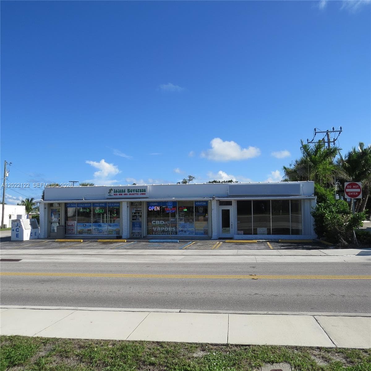 Single-story commercial building featuring an expansive glass storefront, flat roofline, paved frontage with parking stalls, and exterior signage mounting points