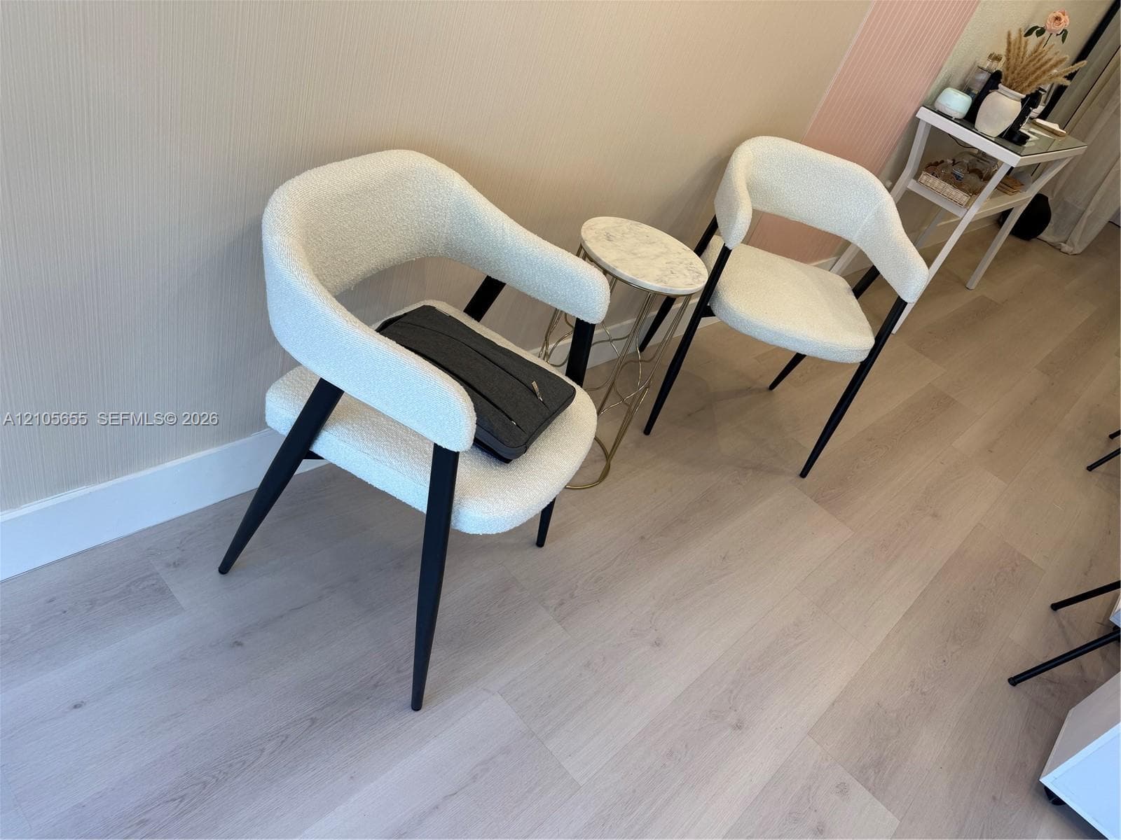 Wood-finish flooring paired with neutral wall treatments featuring a textured finish and vertical accent paneling