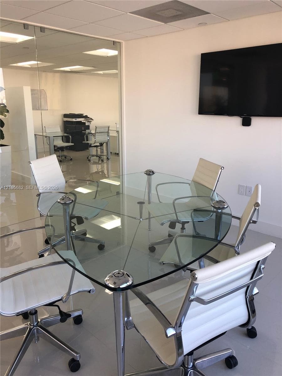 Interior space featuring polished tile flooring, drop ceiling with recessed lighting, and glass partition wall