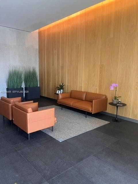 Full-height wood paneling, dark large-format tile flooring, and integrated cove lighting