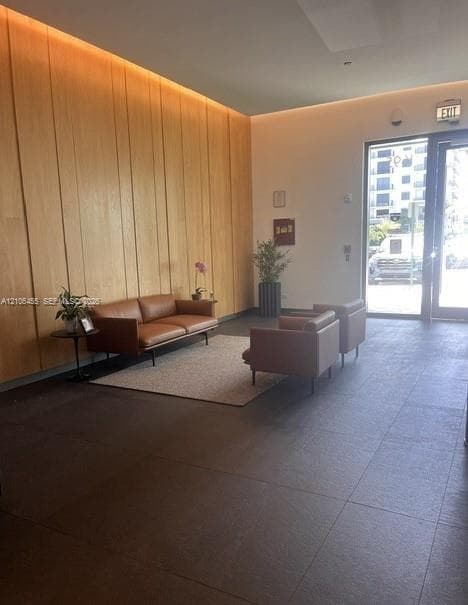 Full-height vertical wood-panel accent wall with integrated cove lighting and large-format tile flooring