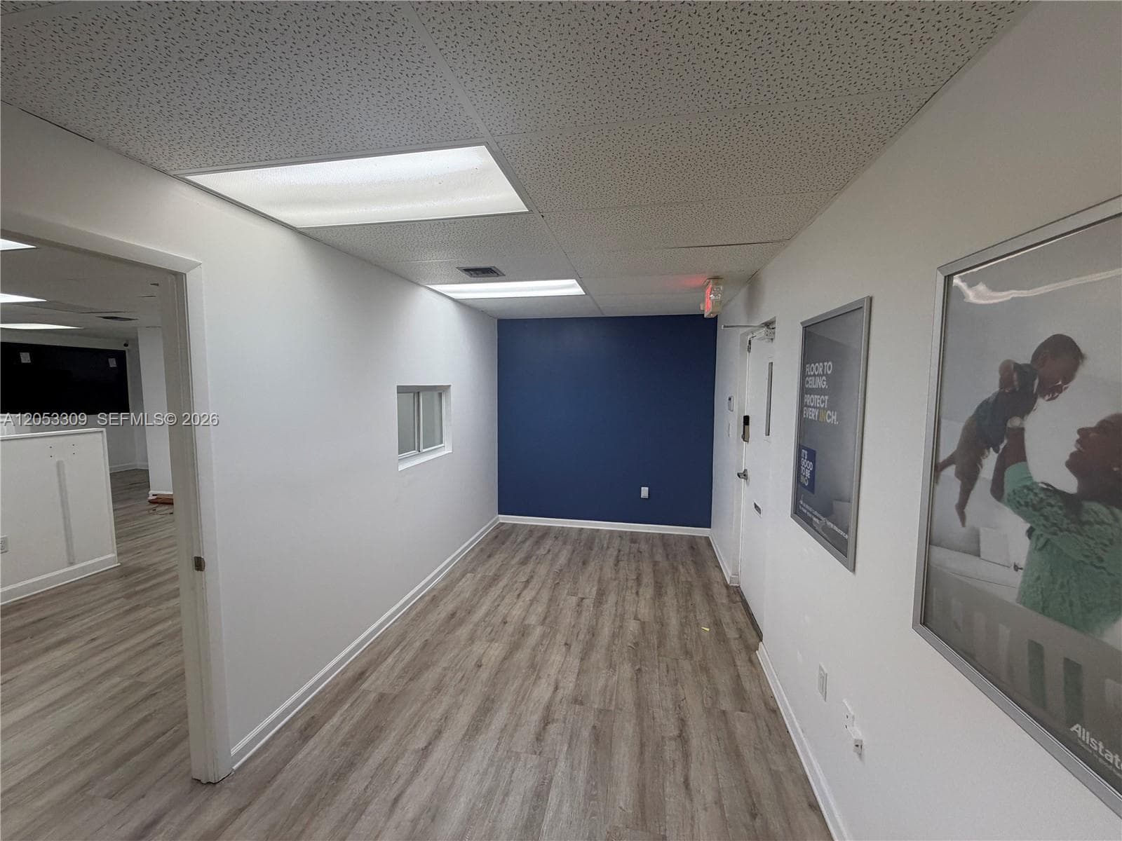 The door on the right is the front door. On the left is the open offices. Behind the photos is the private connecting office.