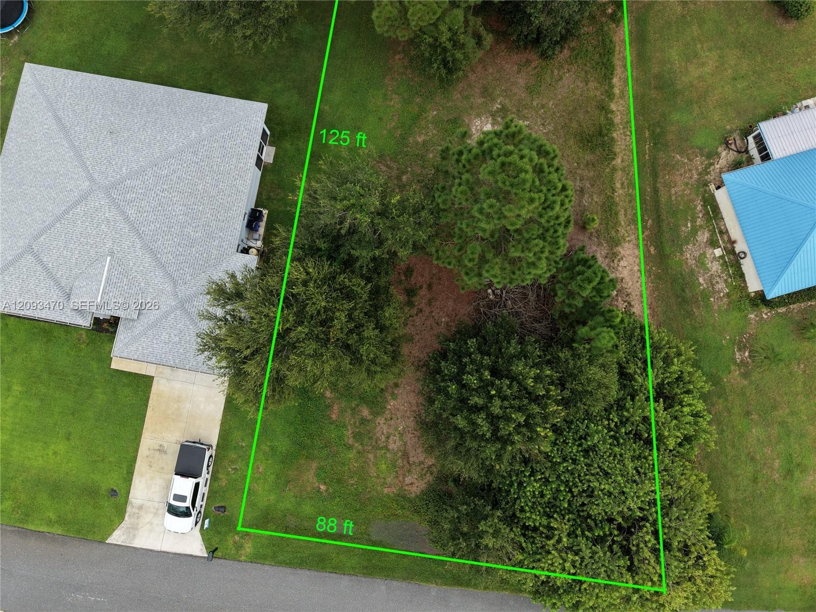 Aerial view of a residential lot featuring established trees, grassy terrain, and dimensions measuring 88 feet by 125 feet