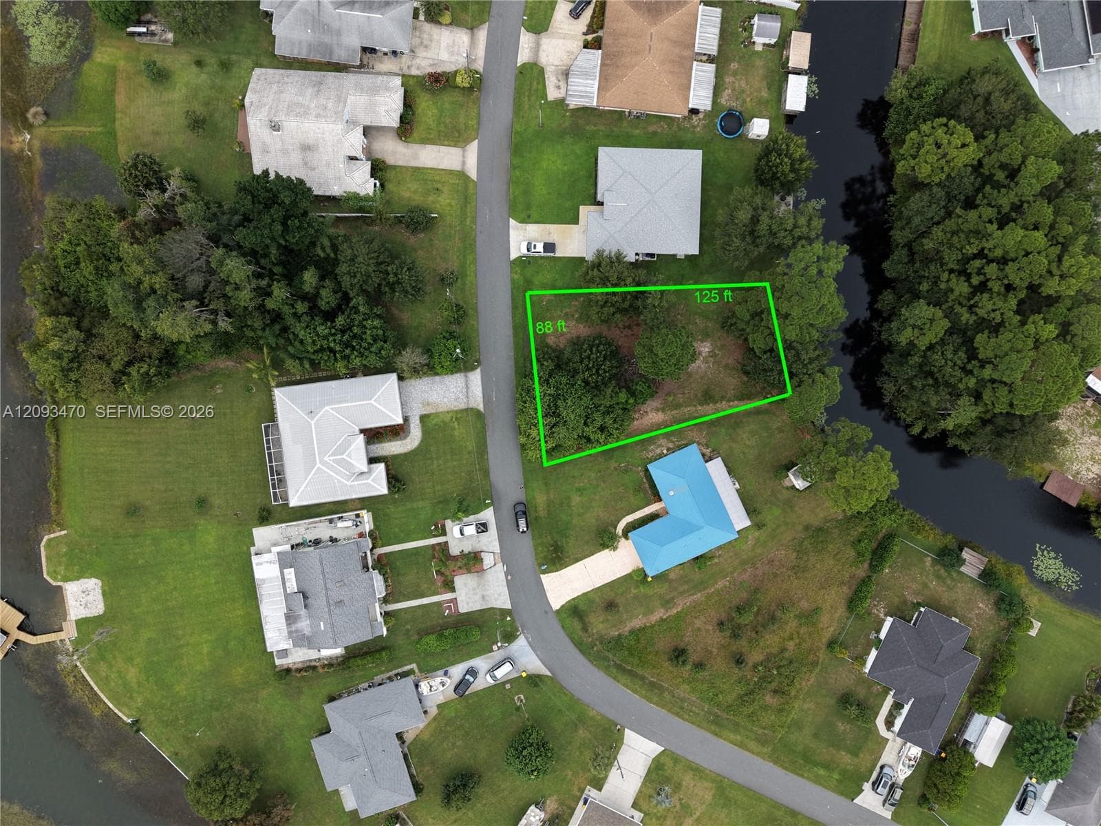 Aerial perspective of a vacant residential lot featuring mature trees and dimensions of 88 feet by 125 feet