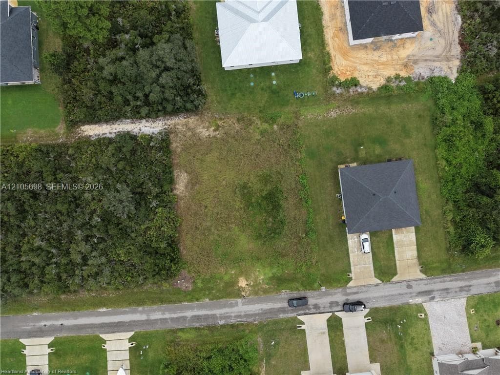 Vacant lot featuring cleared land with surrounding native vegetation and paved road frontage