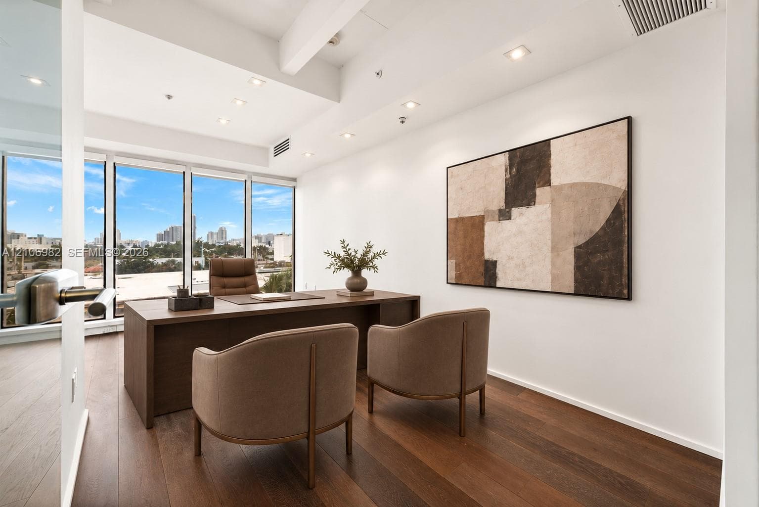 Floor-to-ceiling windows with skyline views, dark wood-finish flooring, recessed lighting, and exposed structural ceiling beam