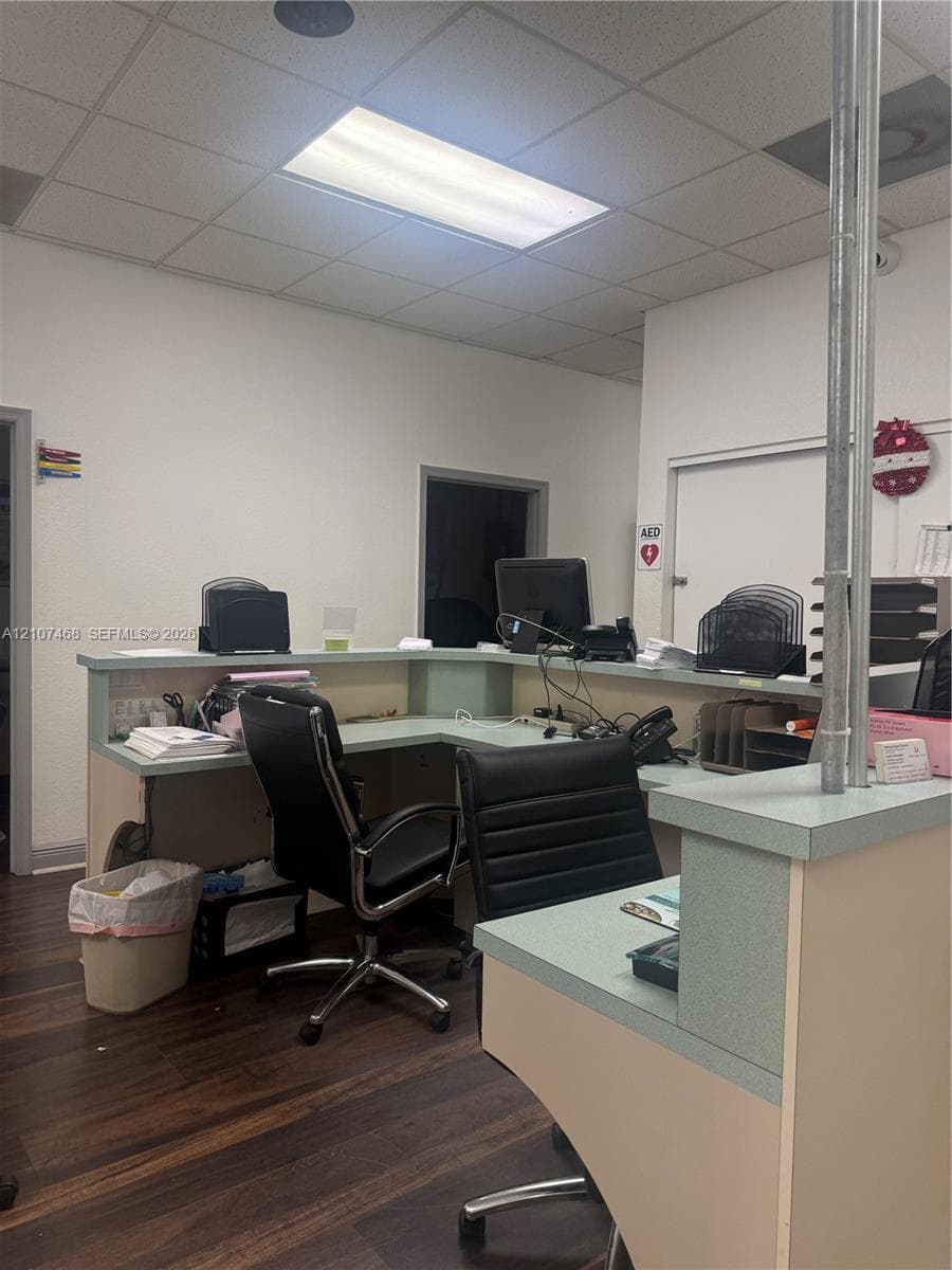 L-shaped reception counter with a light-toned surface and wood-finish flooring
